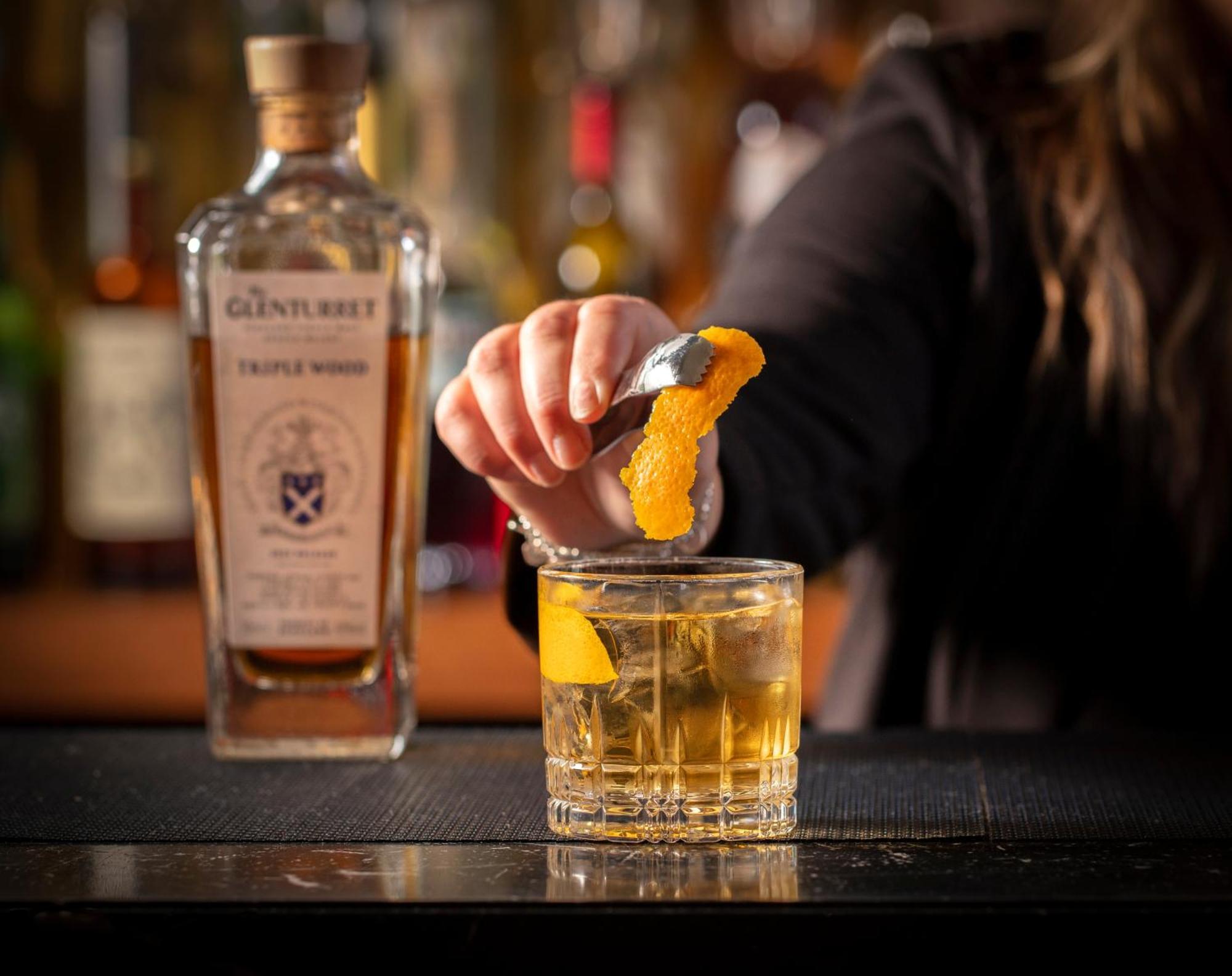 Schloss Roxburghe, Part Of Destination By Hyatt エクステリア 写真 A bartender adding a lemon twist to a glass of GINfinity